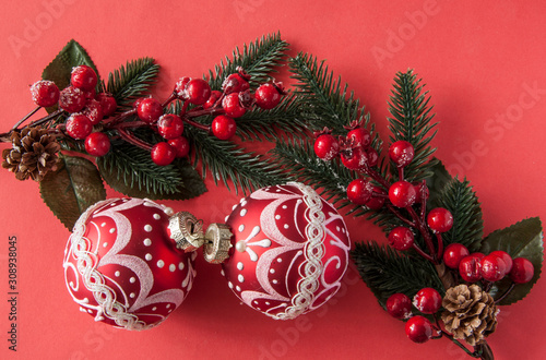 many red christmas balls on red background with copy space. New Year greeting card.