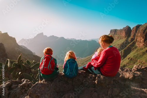 mother with three kids hiking in mountains