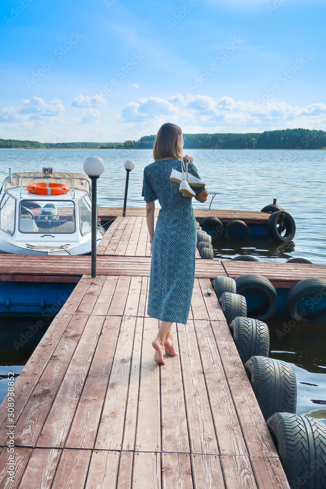 Girl standing near the lake and looking into the distance Girl standing near the lake and looking into the distance