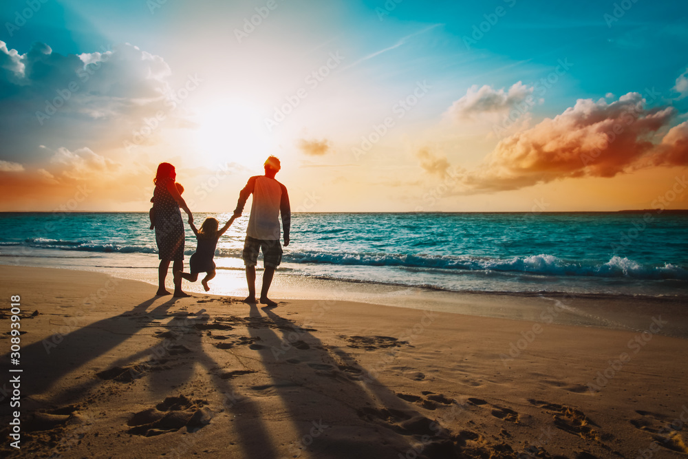 Naklejka premium happy family with kids on play on sunset beach