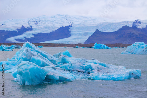 Beautiful photo of Jokulsarlon Glacial lake full of blue floating icebergs.