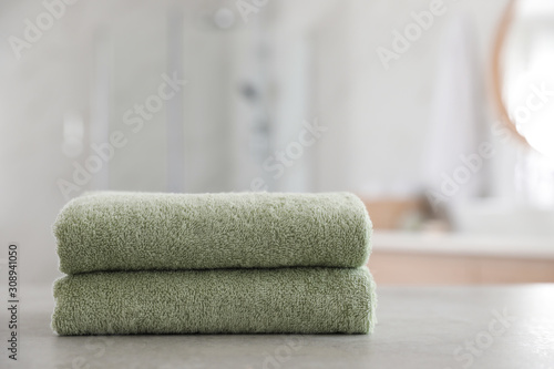 Stack of clean towels on table in bathroom