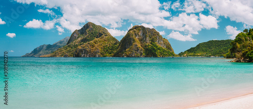 El Nido, Corong Corong beach with massive limestone mountain ridge top with blue lagoon in front. Palawan, Philippines