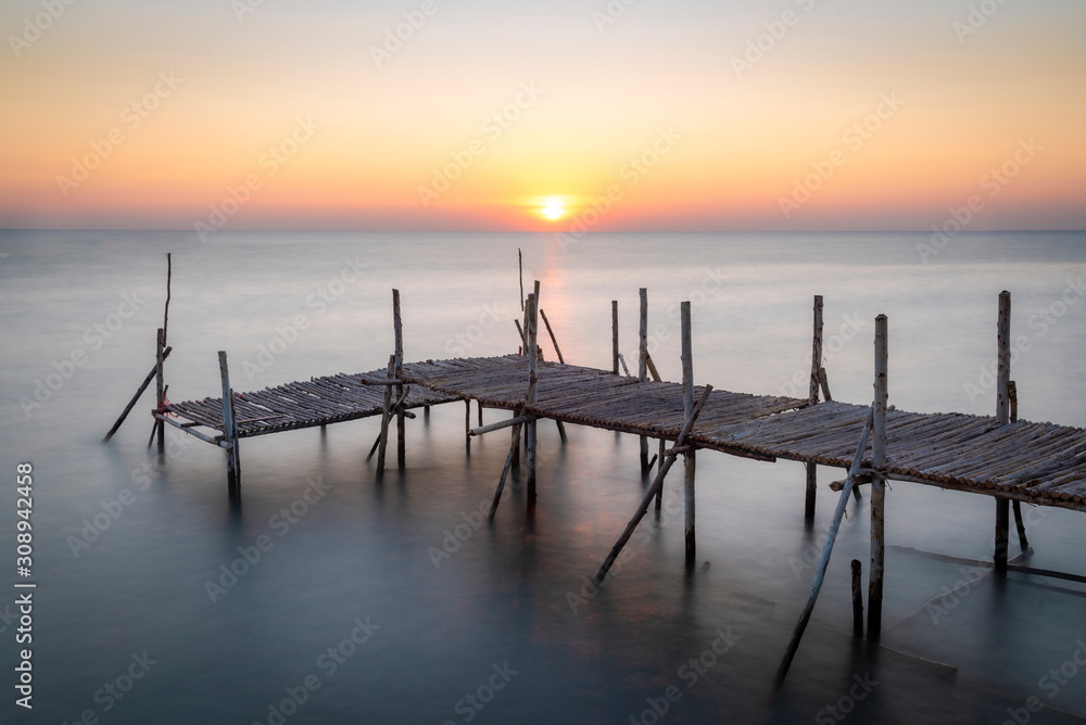 Old wooden bridge at sea in the morning