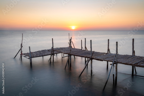 Old wooden bridge at sea in the morning