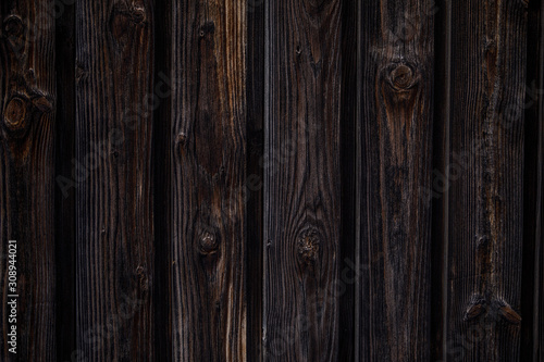 Dark brown wooden background. Vertical boards with knots, dark color.