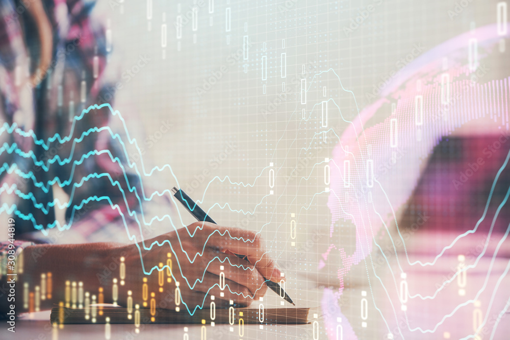 A woman hands writing information about stock market in notepad. Forex chart holograms in front. Concept of research. Double exposure A woman hands writing information about stock market in notepad. Forex chart holograms in front. Concept of research. Double exposure