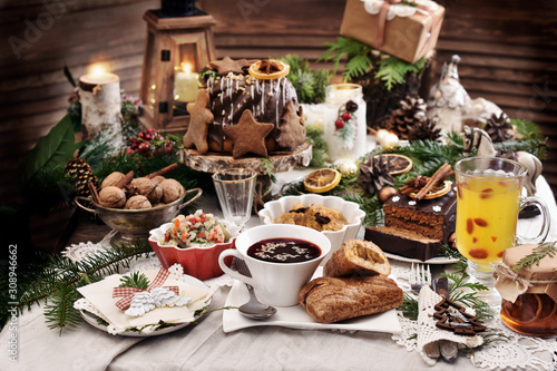 Fototapeta Christmas Eve table with traditional dishes and cakes