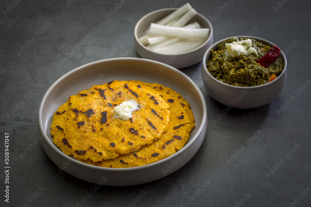 Makki ki roti with sarson ka saag, popular north indian main course menu usually prepared in winter season, using cornmeal breads and mustard leaves vegetables Makki ki roti with sarson ka saag, popular north indian main course menu usually prepared in winter season, using cornmeal breads and mustard leaves vegetables
