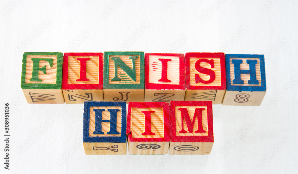 The term finish him displayed visually on a white background using wooden toy blocks image with copy space The term finish him displayed visually on a white background using wooden toy blocks image with copy space