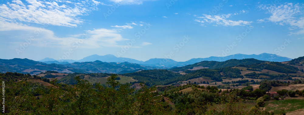 Panoramic photo - mountain ranges going into the distance against a blue sky