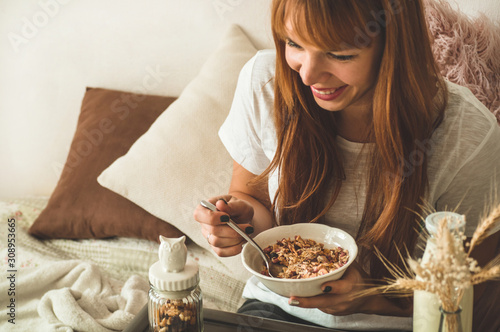 Healthy organic nutrition. Woman enjoying breakfast with oatmeal in bed  free space. 