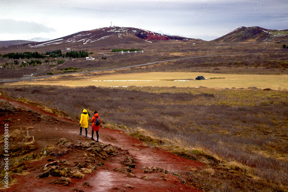 Back view of two women tourists hiking in the mountains in Iceland.