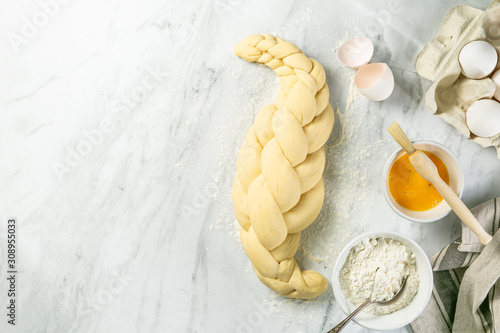 Making traditional jewish challah bread on marble background, copy space