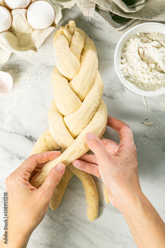 Making traditional jewish challah bread on marble background, copy space photo