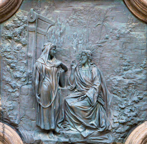 ACIREALE, ITALY - APRIL 11, 2018: The bronze relief of Jesus with the Samaritan woman at the well from the gate of Basilica Collegiata di San Sebastiano probably from 19. cent.
