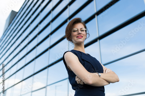 Caucasian woman in office clothes waits colleague near the office building Free Download Caucasian woman in office clothes waits colleague near the office building - GFXLoad