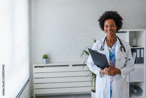 Portrait of female African American doctor standing in her office at clinic photo