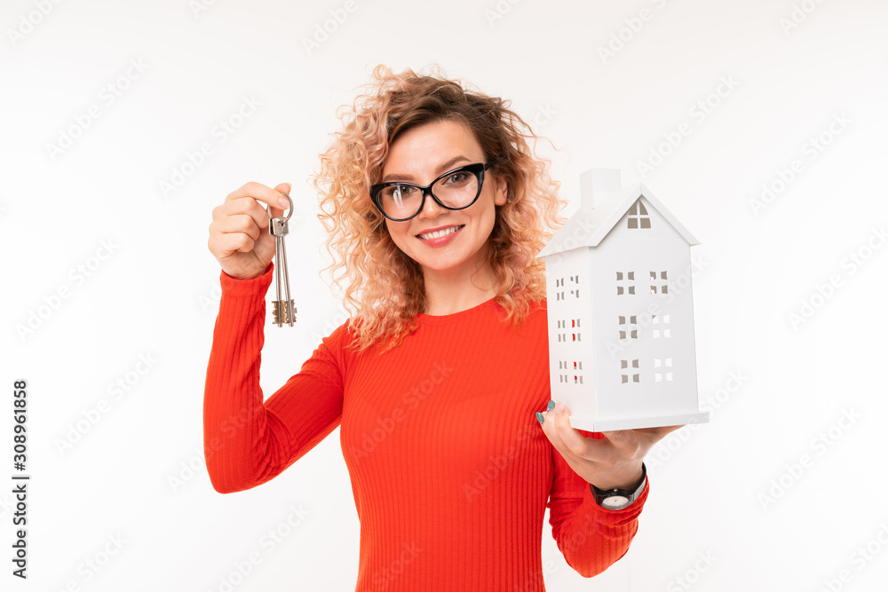 smiling blonde girl with a house layout and keys on a white background