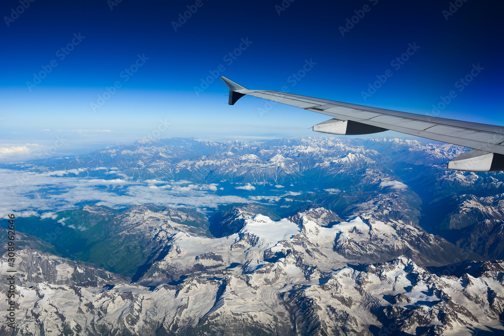 View from airplane to mountains and clouds View from airplane to mountains and clouds