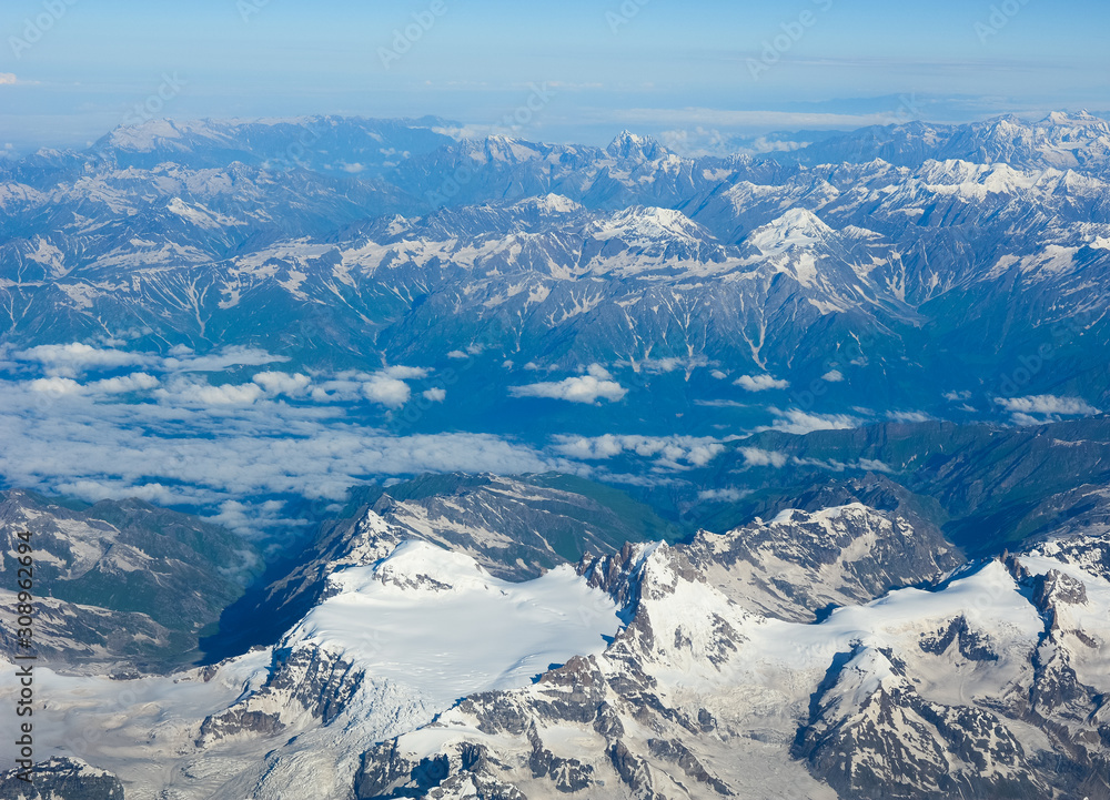Fototapeta premium Aerial view above snow mountain peaks