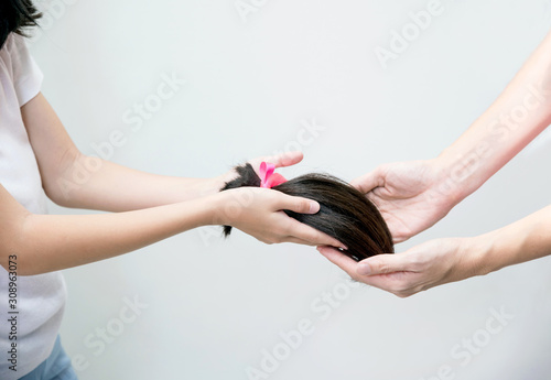 Canvas Print Close up of girl hand donating her healthy hair to cancer patient