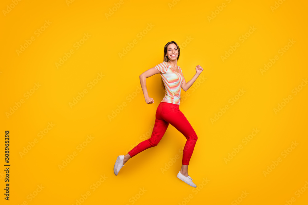 Full body profile photo of funky lady jumping high rushing discount shopping store addicted person wear casual striped t-shirt red trousers isolated yellow color background
