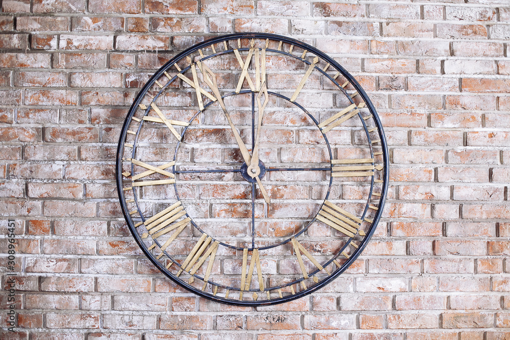 Round iron old fashioned clock on the brick wall. Five minutes to midnight. Round iron old fashioned clock on the brick wall. Five minutes to midnight.