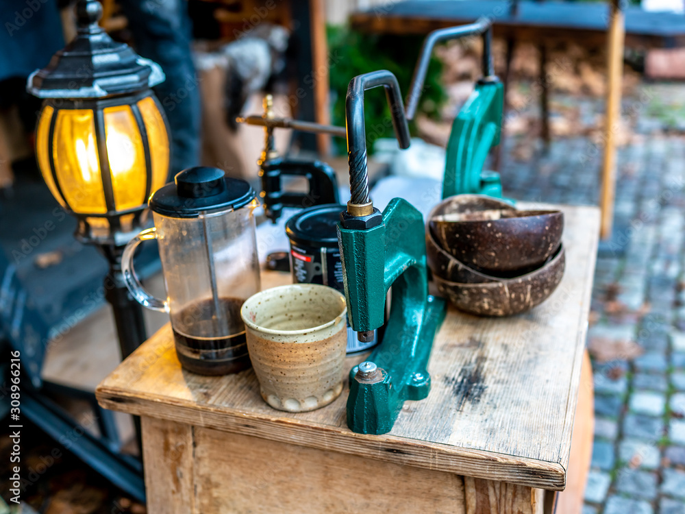 Selective focus on manual coffee bean grinder and utensils on a wooden cabinet on display at the 2019 Christmas market in Maastricht, Netherlands Selective focus on manual coffee bean grinder and utensils on a wooden cabinet on display at the 2019 Christmas market in Maastricht, Netherlands