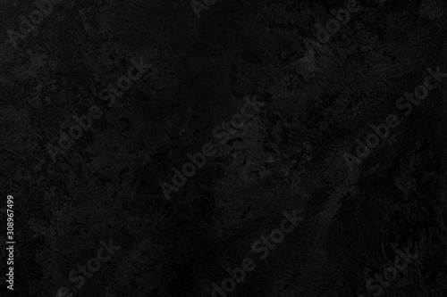 Black low contrast concrete textured wall background with roughness and irregularities to your concept or product.