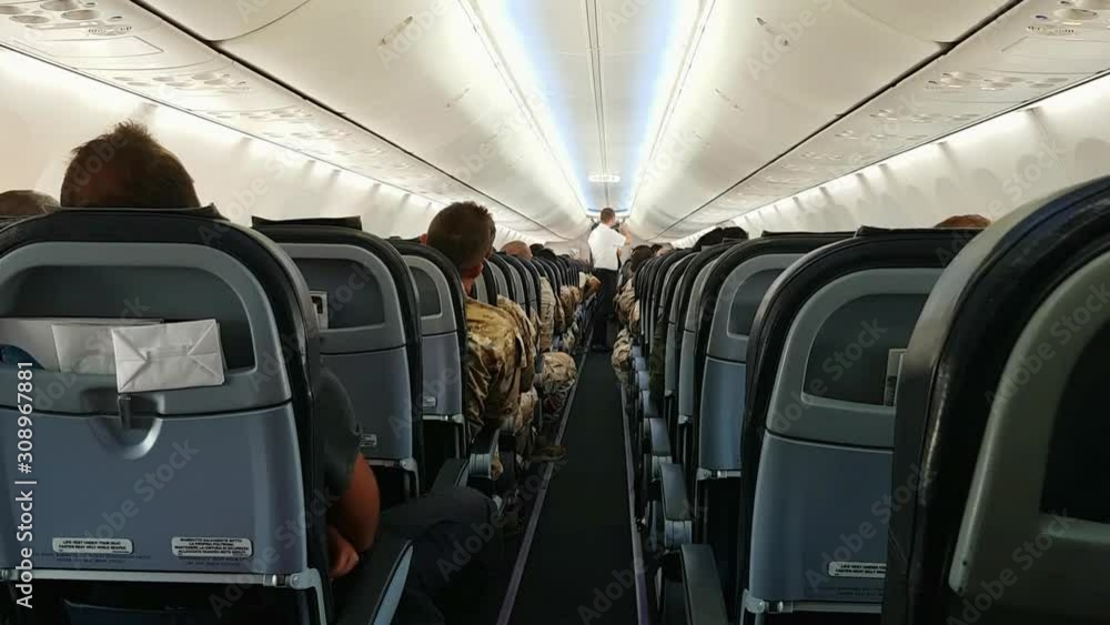 Cabin crew shows passengers emergency exits. Wide angle zoom out shot Cabin crew shows passengers emergency exits. Wide angle zoom out shot