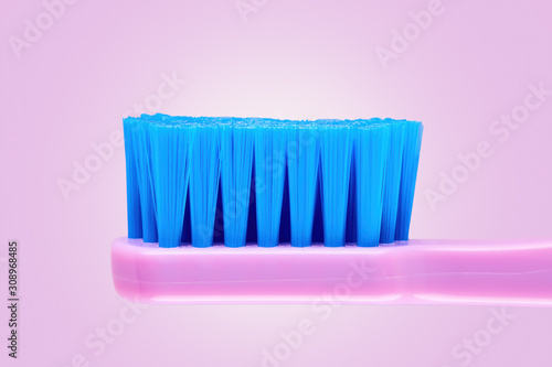 Close up side view of a new purple toothbrush on purple background