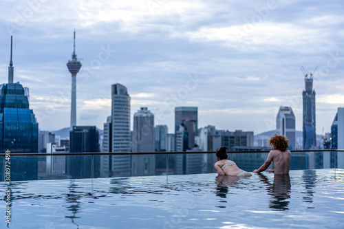 Canvas Print city skyline in kuala lumpur with couple in swimming pool