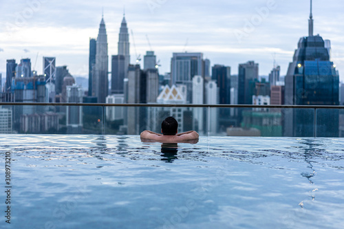 Photography city skyline in kuala lumpur with couple in swimming pool