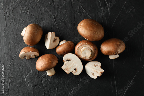 Fresh champignon mushrooms on black background, top view
