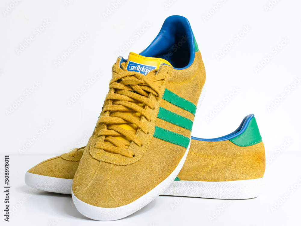 london, england, 05/05/2018 Adidas Gazelle Mustard Gold & Green Stripe  Trainers vintage sneaker trainers. yellow suede adidas trainers, stylish  retro football street fashion. famous three stripes Photos | Adobe Stock