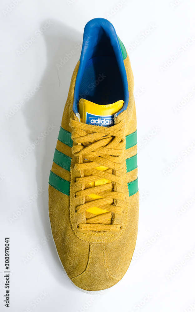 london, england, 05/05/2018 Adidas Gazelle Mustard Gold & Green Stripe  Trainers vintage sneaker trainers. yellow suede adidas trainers, stylish  retro football street fashion. famous three stripes foto de Stock | Adobe  Stock