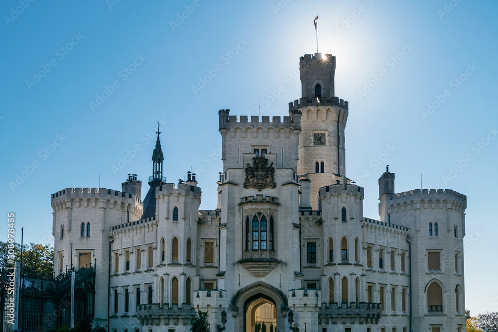Ancient castle with towers and balconies against the sky with sunbeams in the Czech Republic