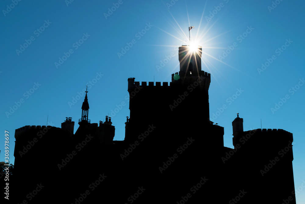 Silhouette of an ancient Hluboka castle with towers on a background of sky with sunbeams Hlubo