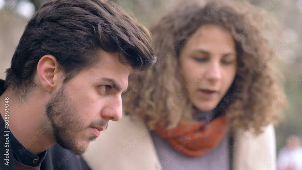 angry young woman at the park discussing with her boyfriend about his treason angry young woman at the park discussing with her boyfriend about his treason