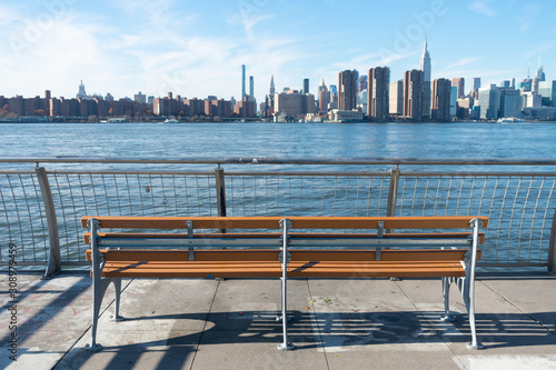 Empty Bench at a Park in Greenpoint Brooklyn New York looking out towards the East River and the Manhattan Skyline photo