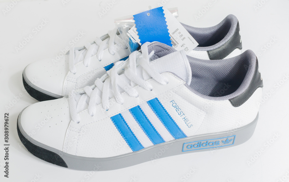 Foto Stock london, england, 05/05/2018 Adidas Forest Hills White grey and blue  vintage sneaker trainers. Blue stripe adidas trainers, stylish retro  football street fashion. famous three stripes | Adobe Stock