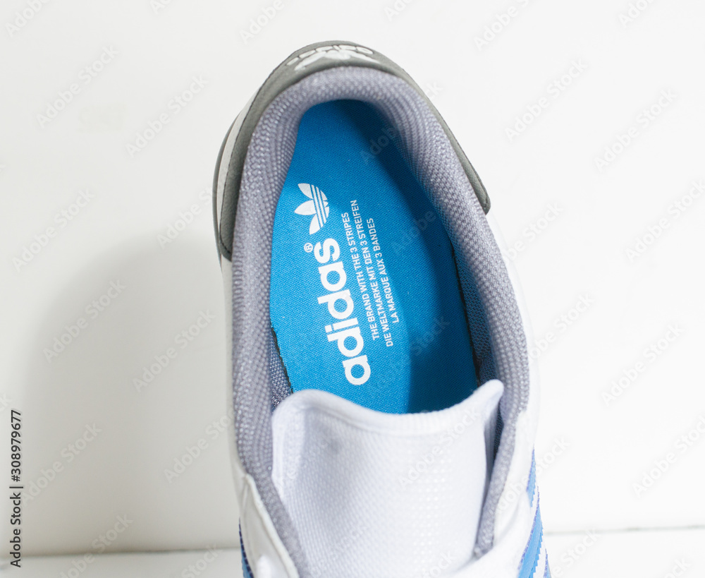 london, england, 05/05/2018 Adidas Forest Hills White grey and blue vintage sneaker trainers. Blue stripe trainers, stylish street fashion. famous three stripes foto de Stock | Adobe Stock