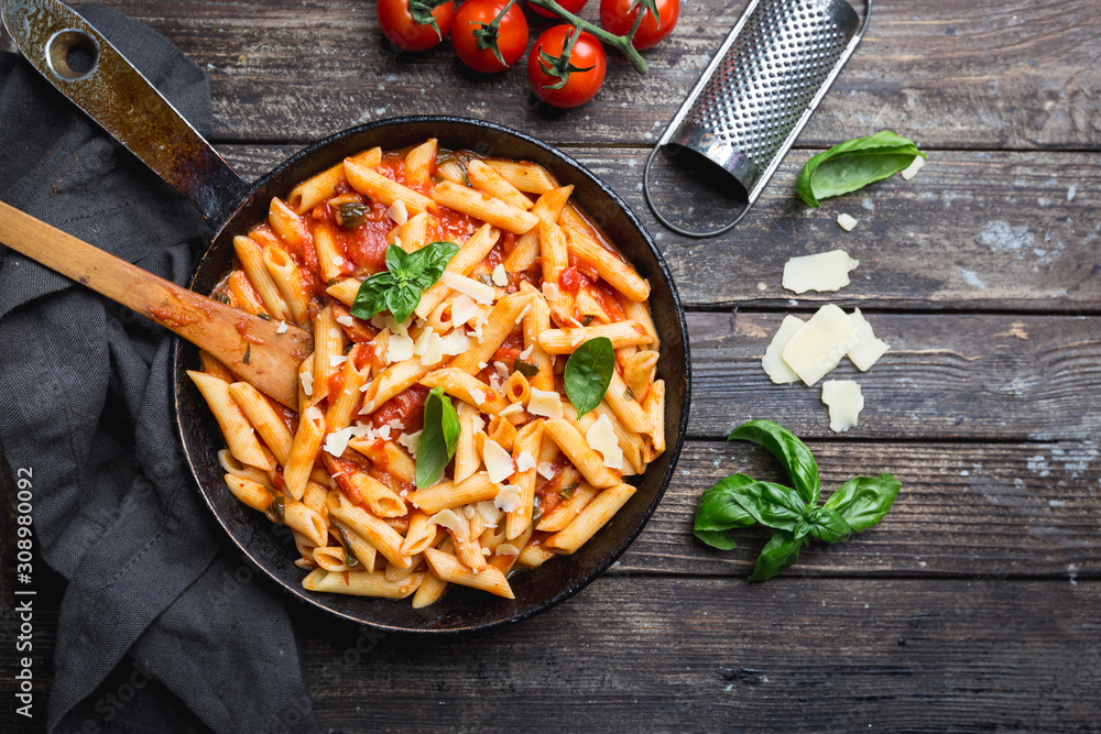 Penne pasta in tomato sauce and cheese decorated with basil on a wooden  background, top view Stock Photo | Adobe Stock