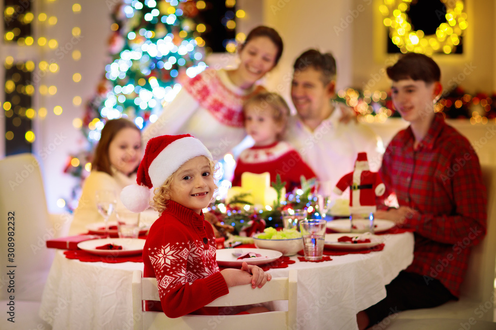 Family with kids having Christmas dinner at tree Family with kids having Christmas dinner at tree