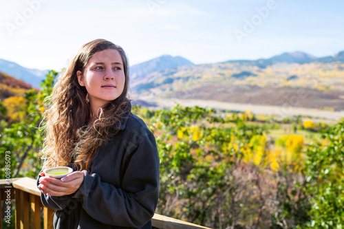 Принти на полотні Young woman with chapped lips standing looking away in garden at home drinking h