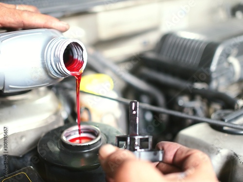 The auto mechanic is refilling additional break fluid after the inspection and repair of the damaged parts.