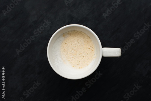 Cup of coffee over the black stone background