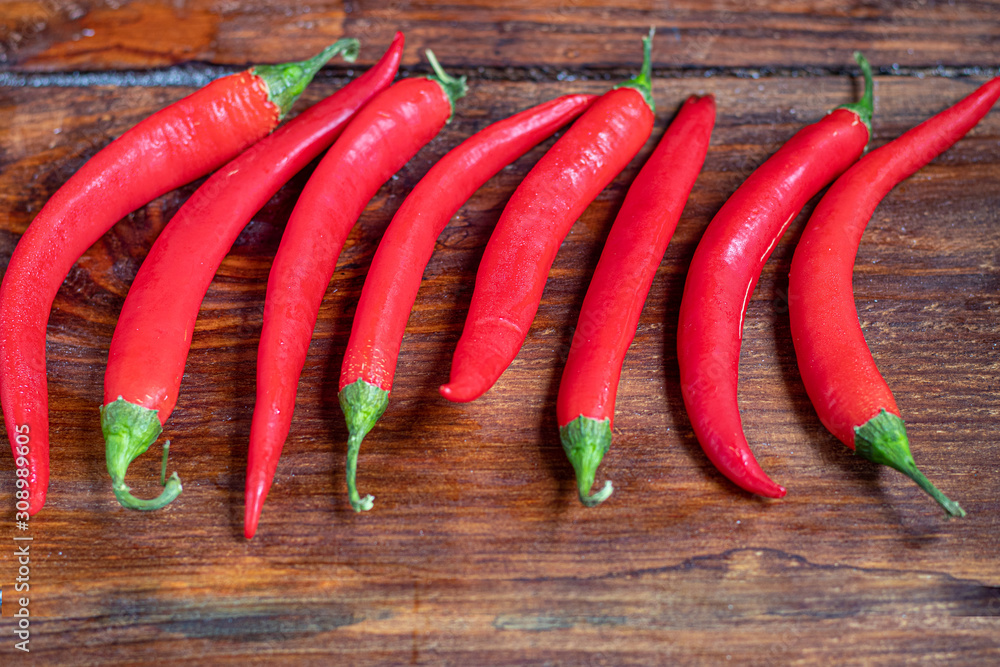 Hot red chili peppers on a wooden surface. Spicy additive in dishes. Hot red chili peppers on a wooden surface. Spicy additive in dishes.