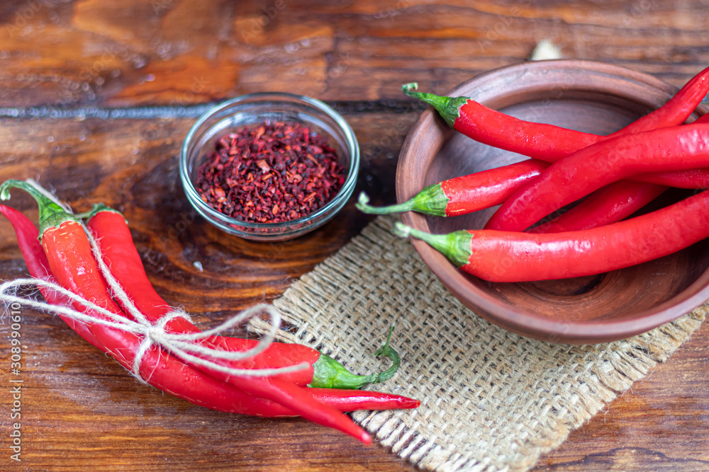 Hot red chili peppers on a wooden surface. Spicy additive in dishes. Hot red chili peppers on a wooden surface. Spicy additive in dishes.